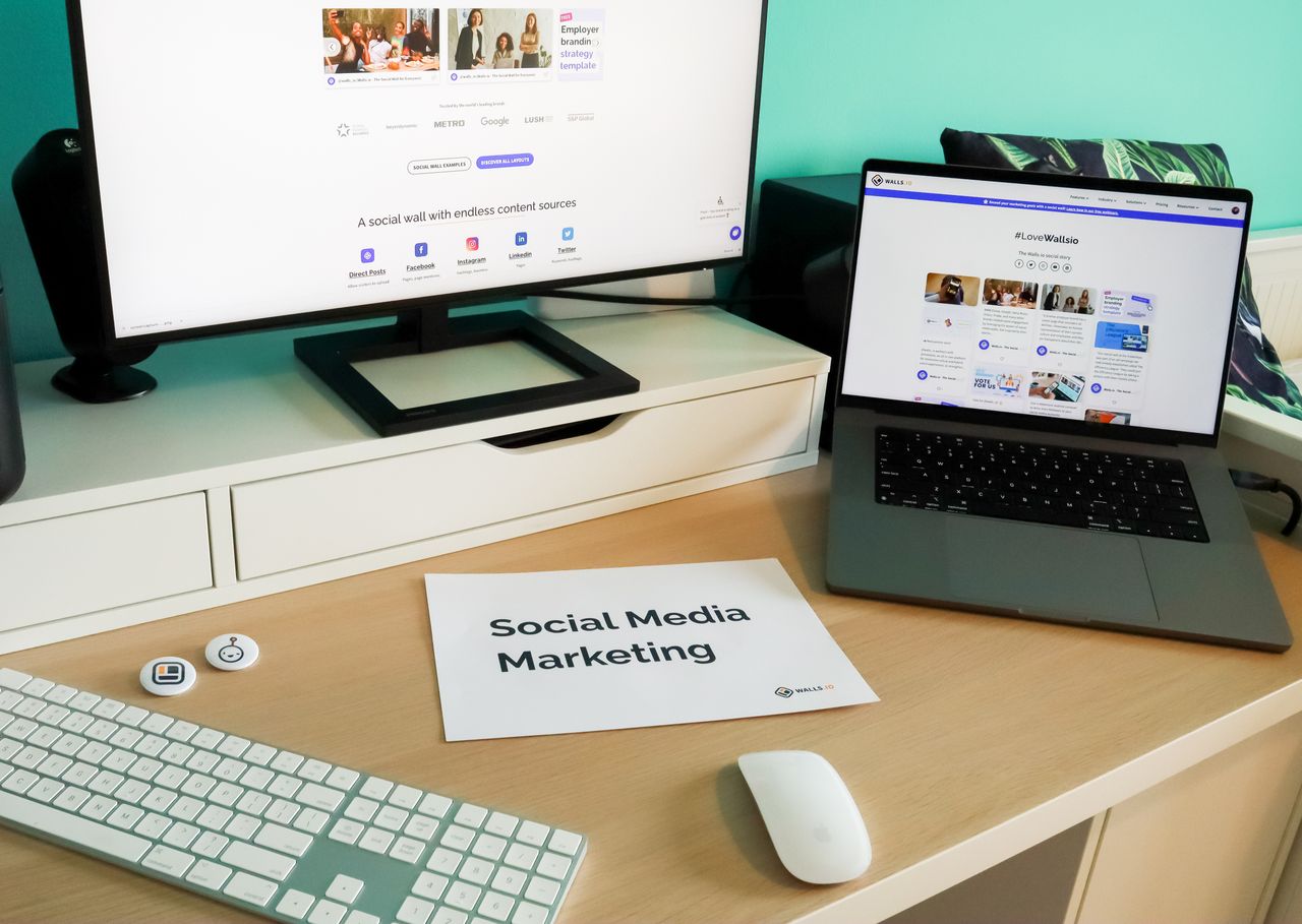 Espace de travail élégant avec ordinateur portable et écran pour le marketing sur les réseaux sociaux.